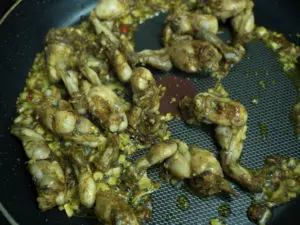 frog legs lemongrass chili being cooked in a pan