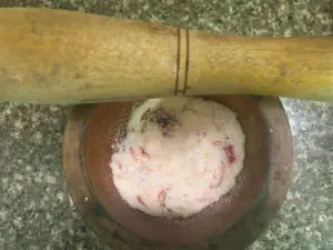Grinding salt and chilies in mortar with a pestle