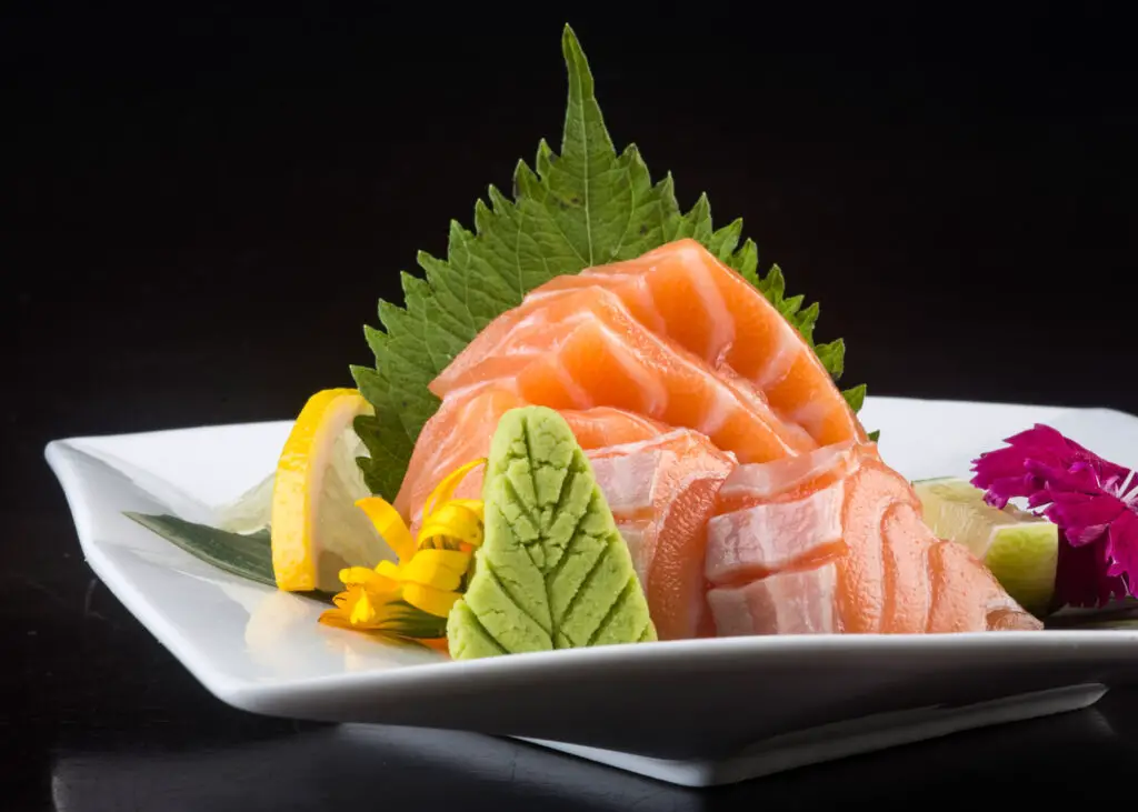 A plate of Japanese sushi with a perilla leaf and perilla leaf-shaped wasabi