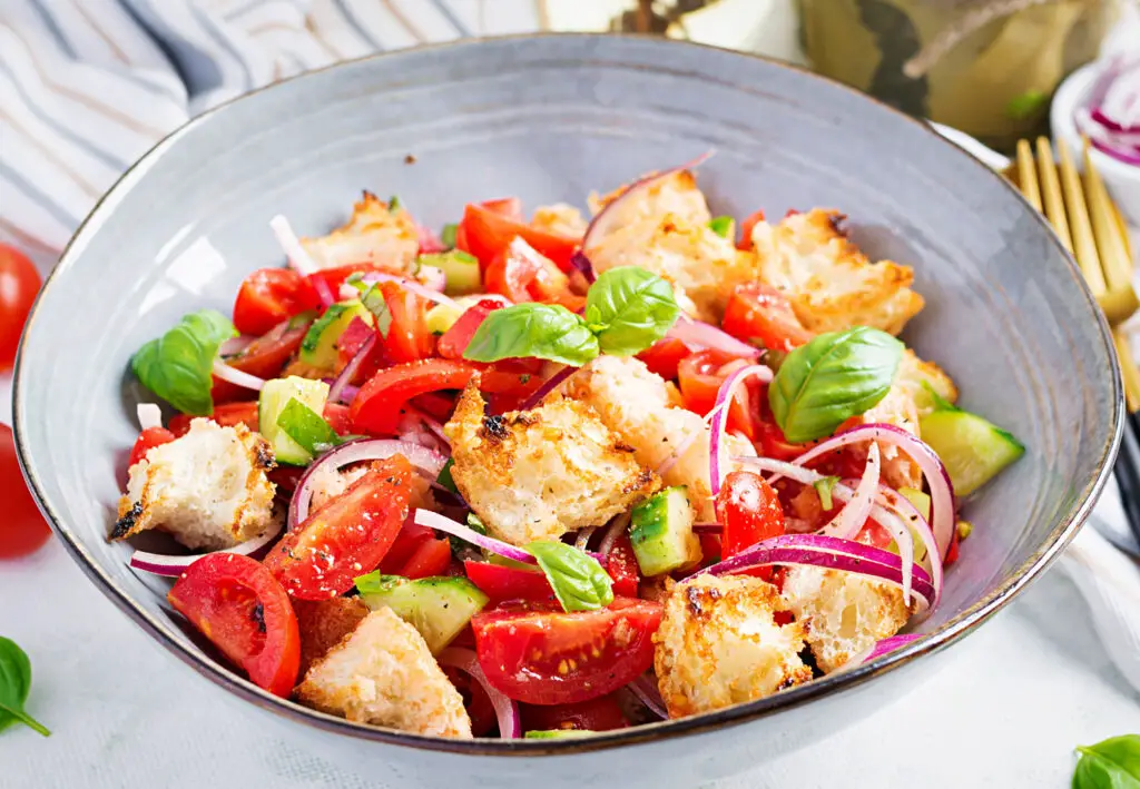 bowl of Panzanella, Tuscan food with bread, tomoatoes, basil, and onions 